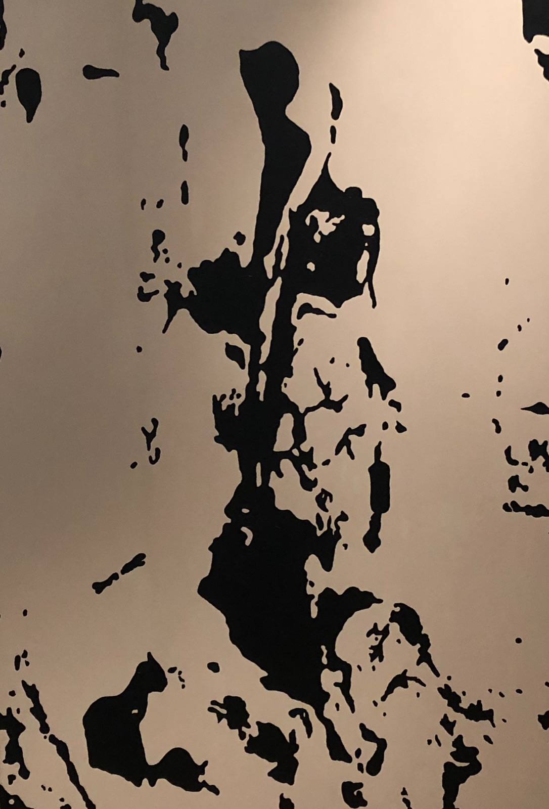 Abstract painting in black on warm sand